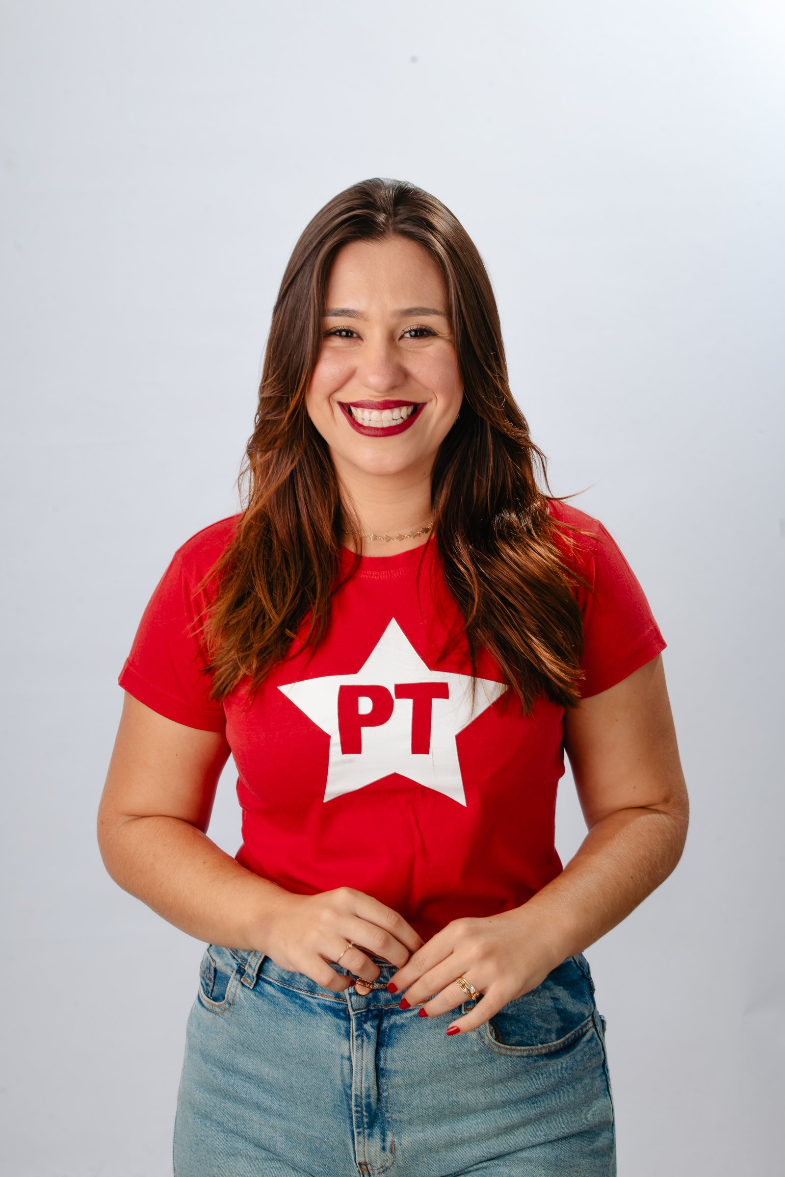 Thálitha Barboza olhando diretamente para a câmera com camiseta do Partido dos Trabalhadores
